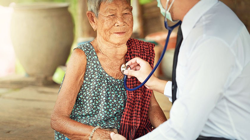 Doctor checks the heartbeat of an older Asian woman