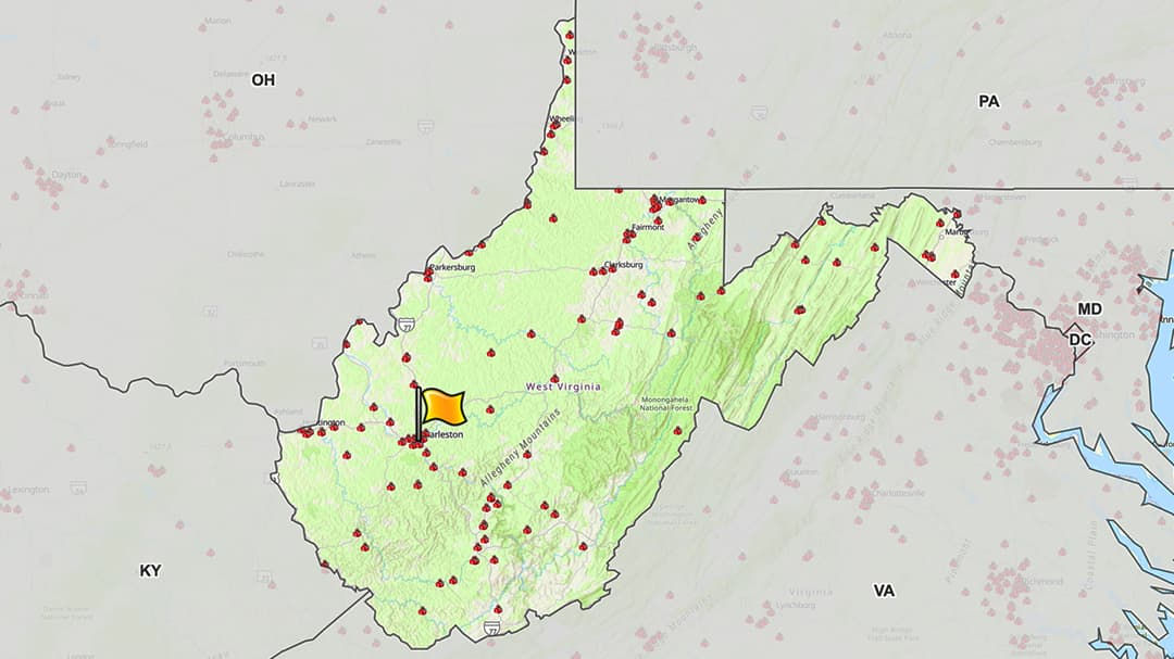 A detailed map highlighting the state of West Virginia, showing seismic activity with red dots and a prominent yellow marker. 