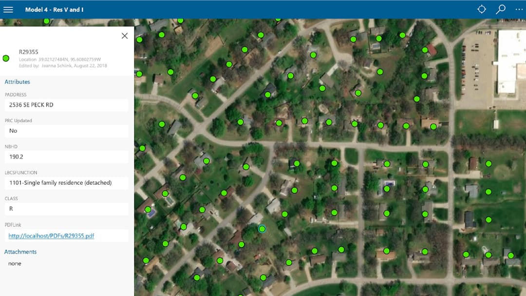 An aerial view of a residential neighborhood with property data points marked by green dots. 