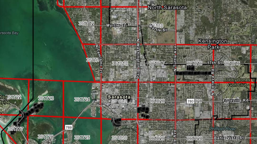 An aerial view of Sarasota, Florida, featuring a detailed map with red grid lines overlaying the city.