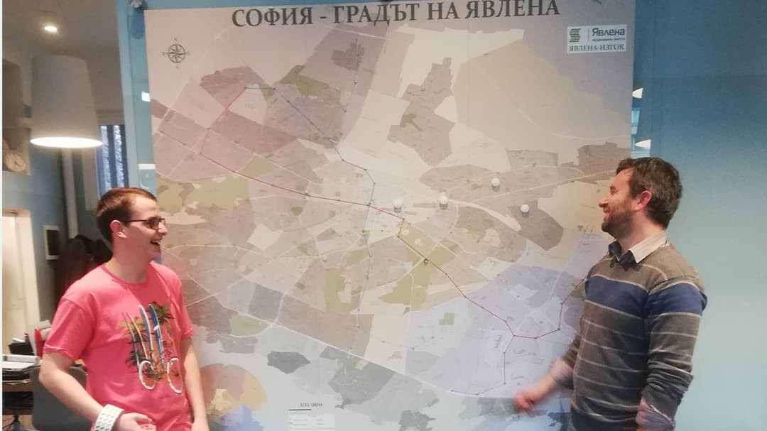 Asparuh Kamburov and Pavel Ivanov stand in front of a large, framed map 