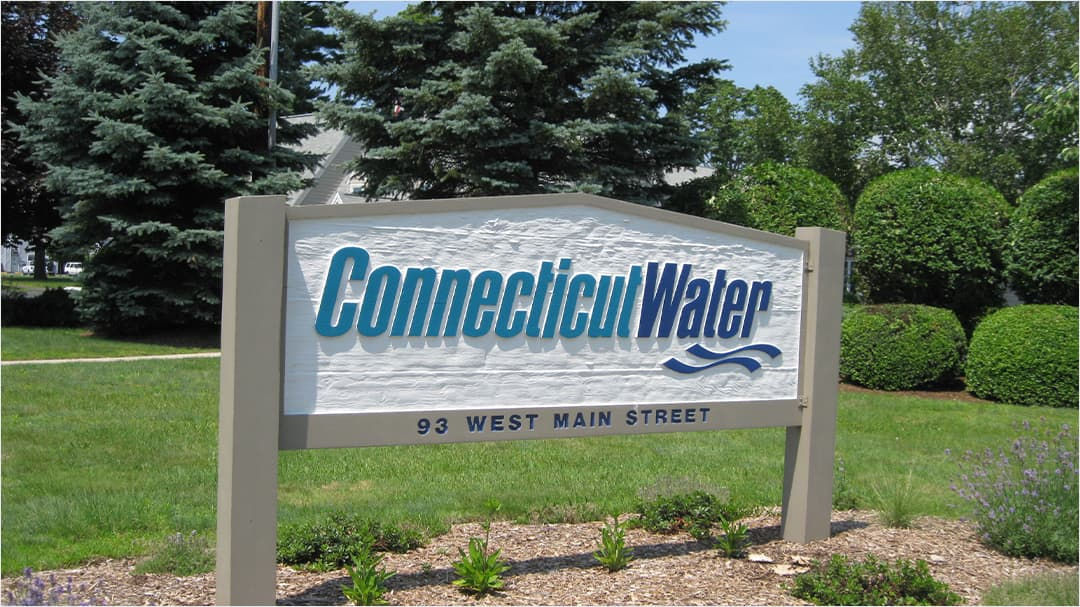 A large outdoor sign displaying 'Connecticut Water' in bold blue text, accompanied by a wave graphic. 