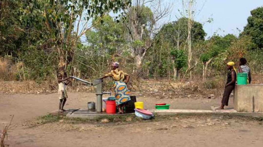Women gather at a water pump in Malawi.