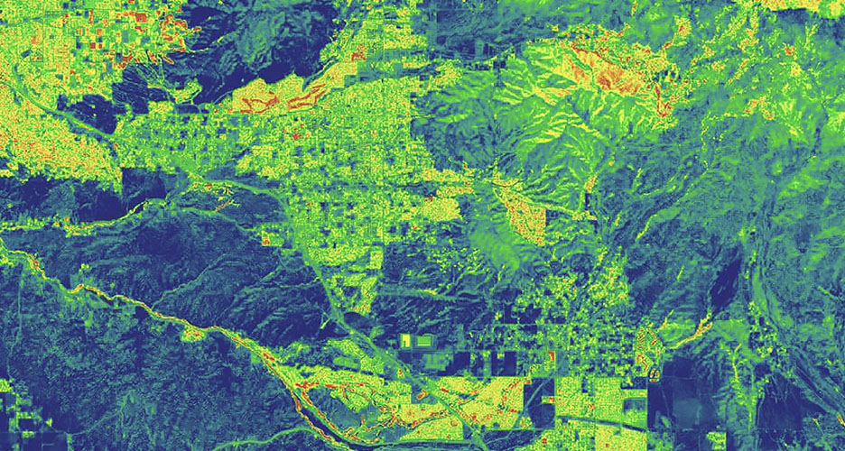 : Luftbild einer Drohne mit geschichteten Schattierungen von Grün und Orange, die Abholzungen und das Problem von Kahlschlägen veranschaulichen 
