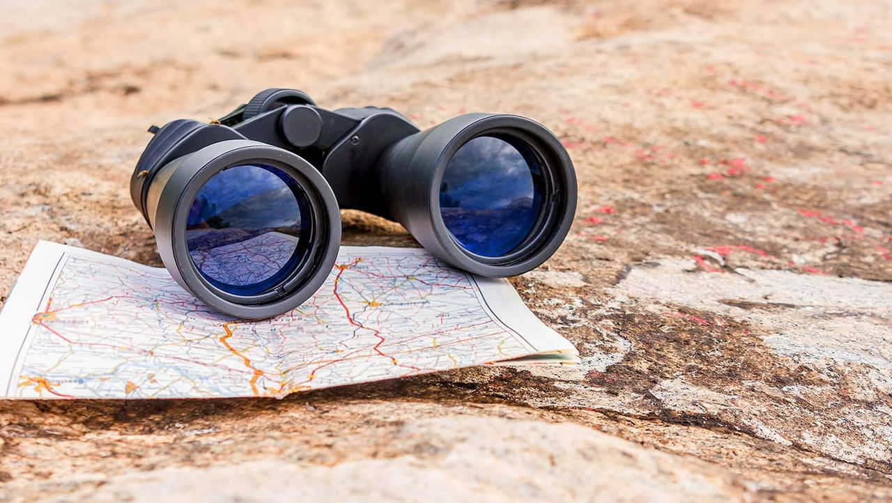 Ein Fernglas, das draußen auf einer gefalteten Karte liegt