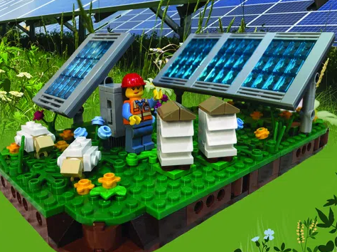 LEGO solar farm complete with LEGO green grass, LEGO Blue solar panels, and a LEGO solar farm worker wearing a red hat