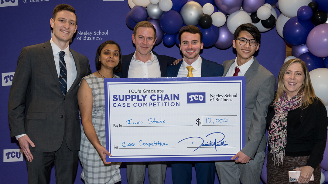 The four winning students, their team advisor, and Cindy Elliot pose with a presentation check for the team’s $12,000 win