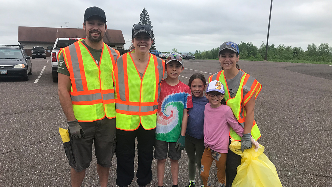 Staff members with family helping clean up highway