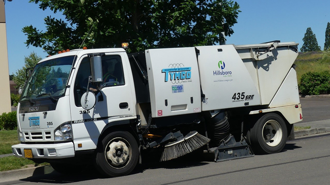 image of a street sweeping vehicle.