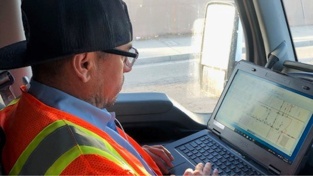 Employee viewing a laptop screen while sitting in a truck