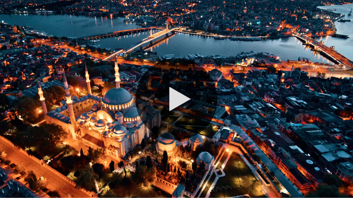 An aerial view of the Blue Mosque, surrounding buildings, and a nearby river in Istanbul, Turkey, at dusk