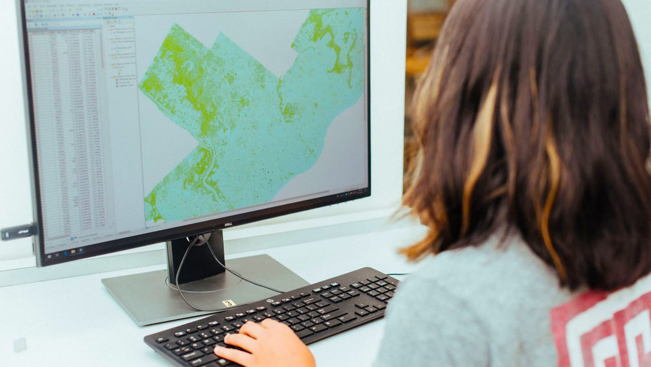 Une personne travaillant sur un ordinateur affichant une carte et des données géographiques