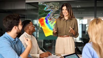 Quatre personnes rassemblées autour d’une table dans une salle de conférence, en pleine discussion, avec une grande carte affichée au mur derrière eux