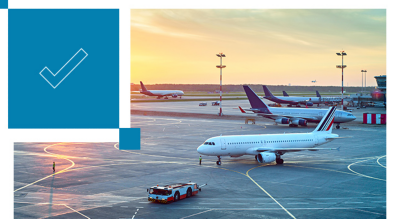 Multiple airplanes are stationed at an airport terminal during sunset, with a clear sky and warm lighting.