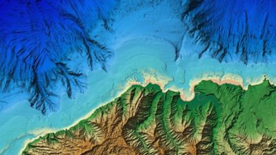 Carte topographique 3D du fond de l’océan en bleu foncé et des terres côtières en vert et marron