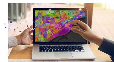 Deux mains pointant vers une carte multicolore sur un ordinateur portable