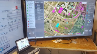 A computer screen displays large-format interactive maps pinpointing medical tents and first aid stations