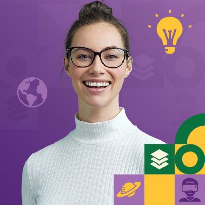 Cheerful person wearing glasses and a white sweater with their hair pulled into a bun