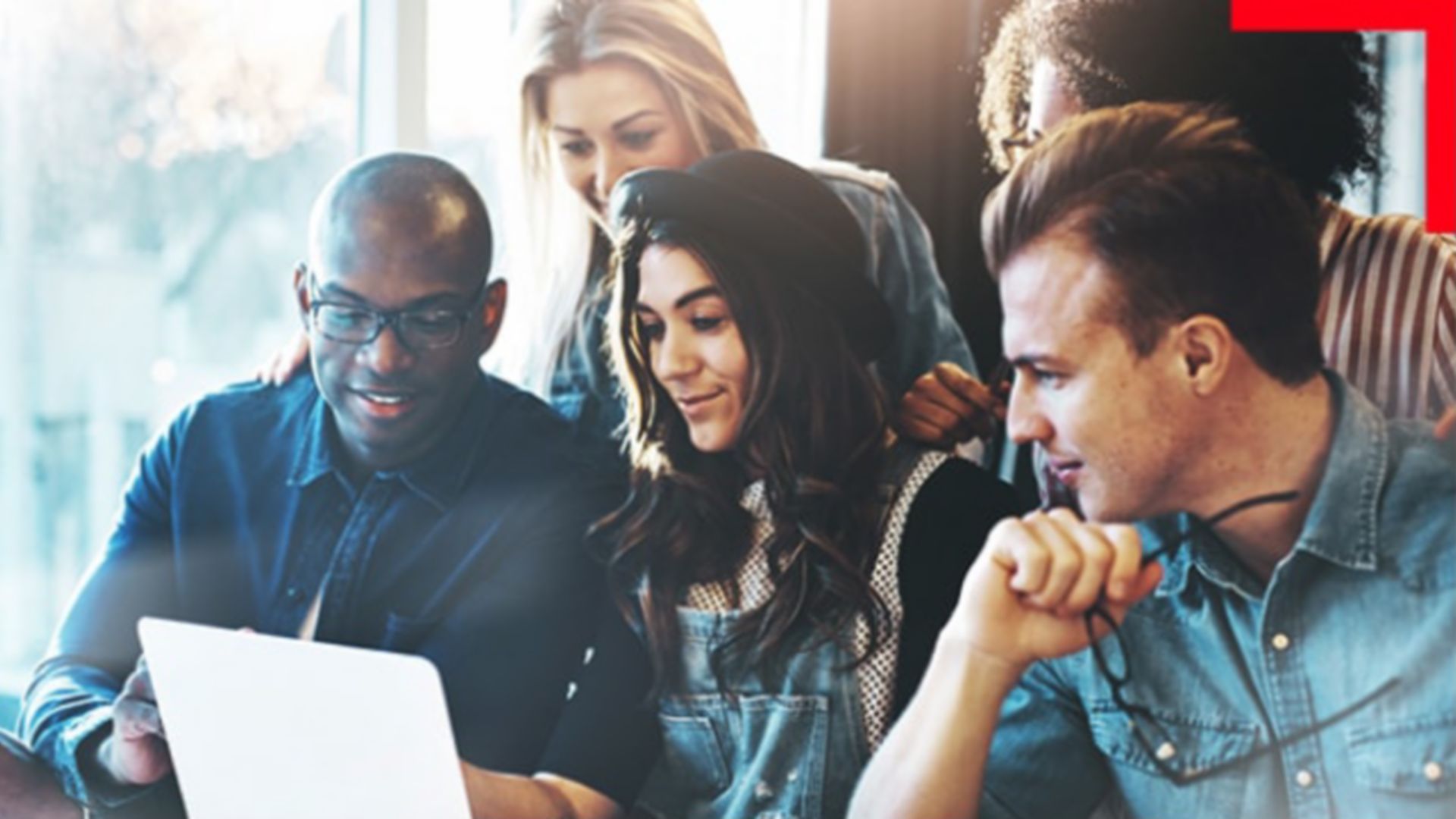 A group of five people looking at a laptop together