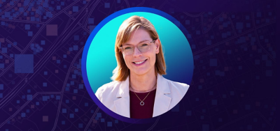 Portrait of Emily Champagne smiling in a sunlit courtyard