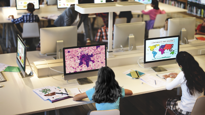 Interior photo of a modern high school with students climbing the stairs and walking through the hallways