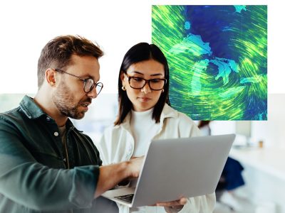 Two people discussing a shared laptop display in a sleek modern office overlaid with a small green and blue map