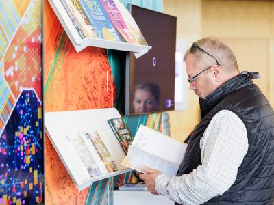 Attendee looking at GIS books set up on a colorful display shelf