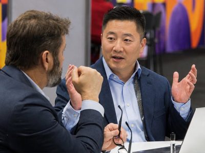 Two attendees in business attire seated and engaged in discussion