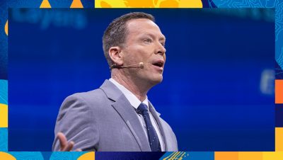 Presenter ina suit and tie speaking onstage