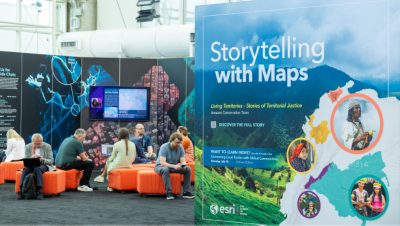 A section of the Expo with colorful and vibrant graphics and informational posters and attendees seated on bright orange ottomans