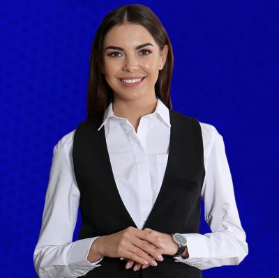 Smiling person wearing a white button up shirt and a formal black vest