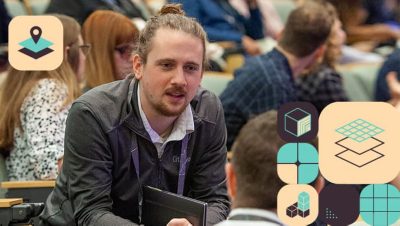 Attendee seated in a crowd leaning over to talk to the person next to them