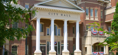 A red brick City Hall building with four white columns at the entrance