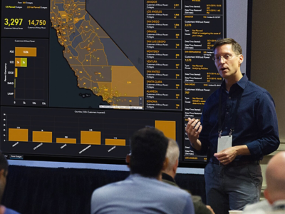  Redner, der eine Präsentation hält, mit einer Karte und einem Dashboard mit Statistiken in Bezug auf den Bundesstaat Kalifornien.