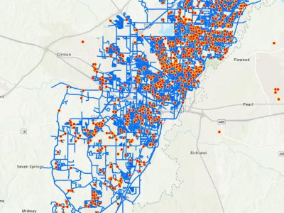 Detailed map of Jackson with a dense network of blue lines representing pipelines overlaid with red dots