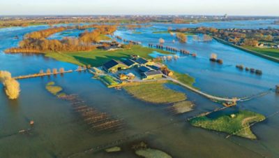 Huis in de polder omringd door hoog water na een overstroming