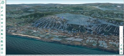 A 3D aerial perspective reveals a coastal town nestled amidst farmland and rolling hills