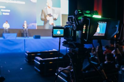 Event attendees studying a brochure paired with colorful abstract graphics