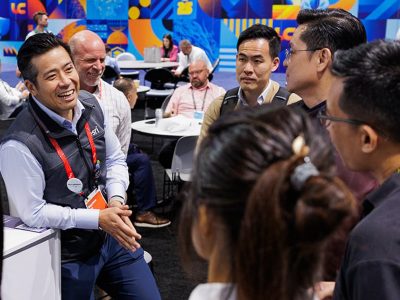 A group of attendees visiting a booth in the Esri showcase and interacting with a staff member