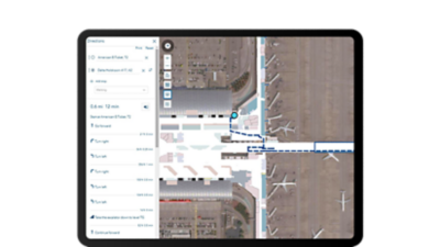 A tablet screen showing an overhead shot of an airport terminal with turn-by-turn directions on the left