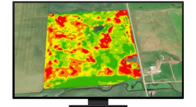 A composite aerial photo of green farmland with an overlaid heat map in brighter green, orange, and red