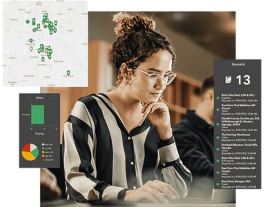Elections office worker using a computer, with a map of polling places, an incident log, and a status graph to the side