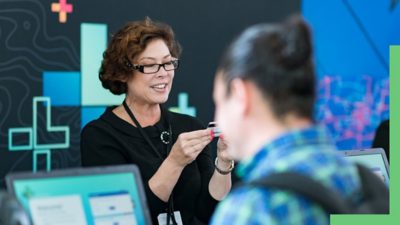 Person at a registration desk checking attendee ID at an event
