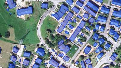 Aerial image of a suburban neighborhood with each structure outlined in vivid blue