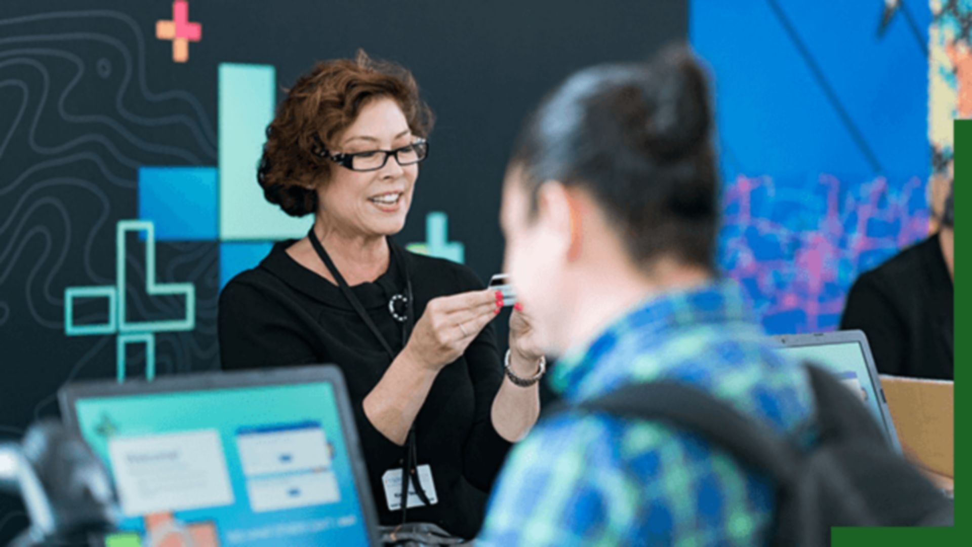 A woman is assisting attendees at a registration desk during an event