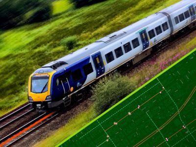 A modern, fast moving commuter train on tracks overlaid on a green asset map