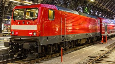 A modern red passenger train standing in a station