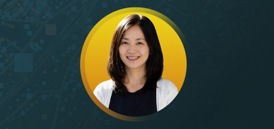 Leigh Chan smiling in front of a yellow and teal background