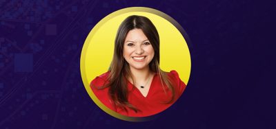 Portrait of Lizzete de Leon Bocanegra smiling in a red blouse with a flat yellow background