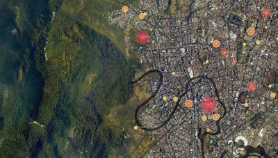 A satellite view of a densely developed area and a nearby greenspace with various locations pinpointed by orange and red circles